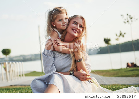 Happy young mother with a playful daughter in a park near the water 59888617