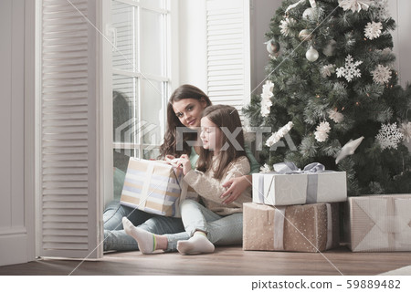 Mother and daughter unpack christmas gift Mother and daughter unpack christmas gift 59889482