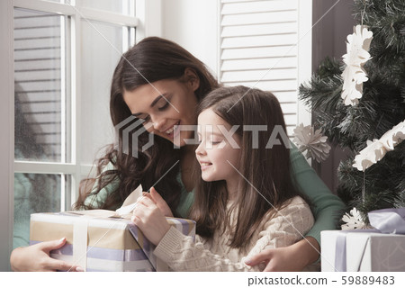 Mother and daughter unpack christmas gift 59889483