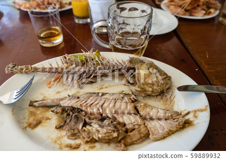 Bones of eaten fish on a table in a restaurant Bones of eaten fish on a table in a restaurant 59889932