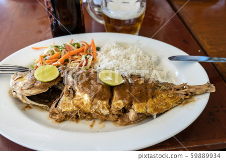 Grilled fish with salad and side dish on a table in a restaurant 59889934