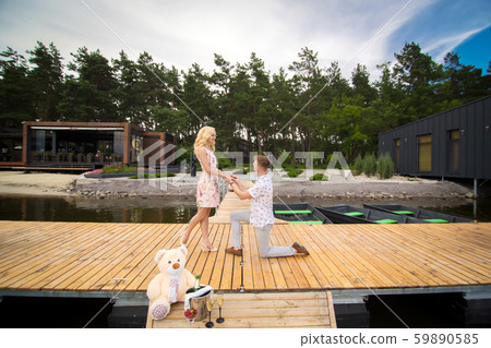 Young cute guy makes a marriage proposal to his 59890585