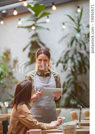 Cheerful Waitress Talking to Client at Cafe Terrace 59892671