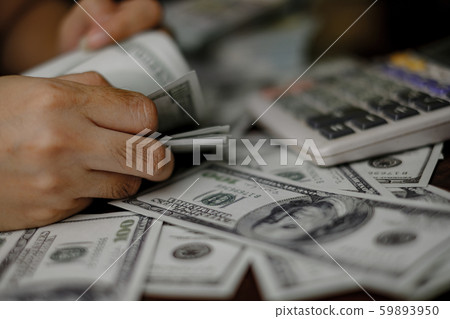 Businessmen women counting money on a stack of 100 US dollars banknotes lots of money 59893950