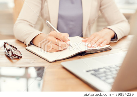 Closeup Businesswoman Writing at Workplace 59894229