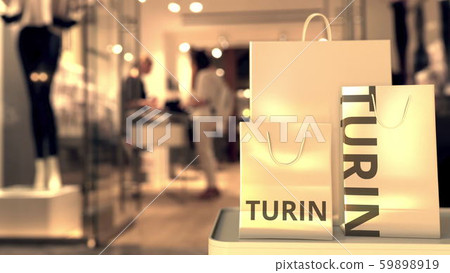 Paper shopping bags with Turin caption against blurred store entrance. Retail in Italy related 3D Paper shopping bags with Turin caption against blurred store entrance. Retail in Italy related 3D 59898919