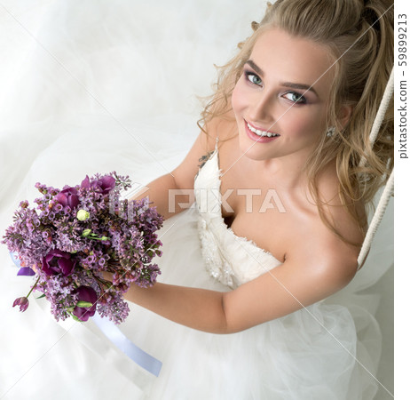 Young bride in studio on swing with fine bouquet Young bride in studio on swing with fine bouquet 59899213