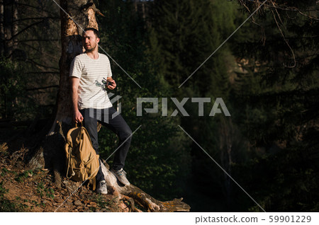 Hiking man portrait with backpack walking in nature. Caucasian man smiling happy with forest in Hiking man portrait with backpack walking in nature. Caucasian man smiling happy with forest in 59901229