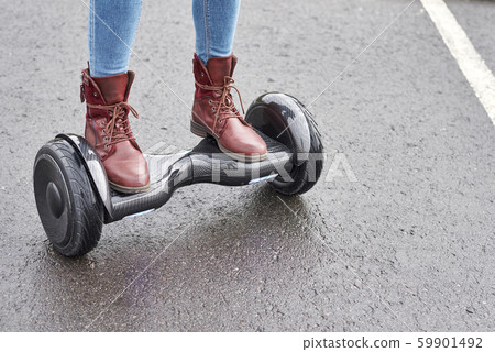 Close up of woman using hoverboard on asphalt Close up of woman using hoverboard on asphalt 59901492
