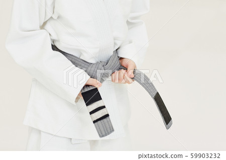 Young judoist getting a belt 59903232