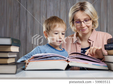 five years old child reading a book at home with mother five years old child reading a book at home with mother 59903511