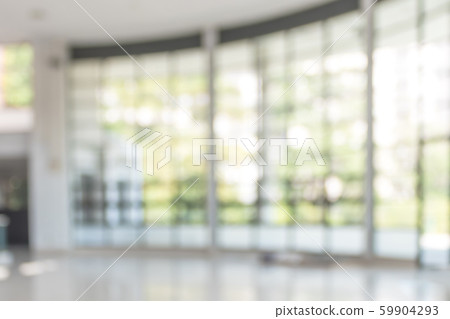 Blur background interior view looking out toward to empty office lobby and entrance doors and glass curtain wall 59904293