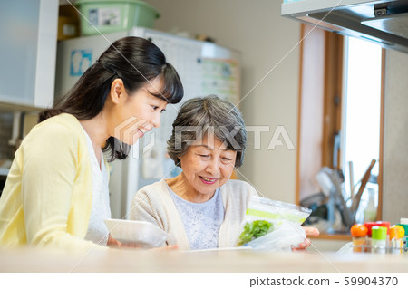 Parent and child standing in the kitchen, mother and child, senior woman, middle woman, 2 people Parent and child standing in the kitchen, mother and child, senior woman, middle woman, 2 people 59904370