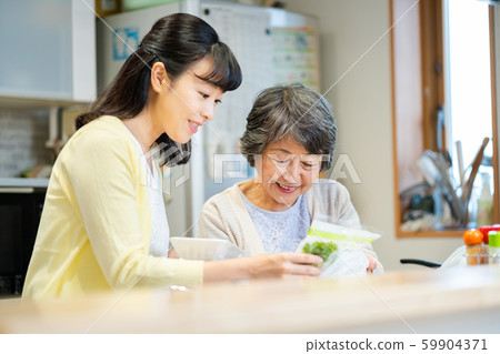 Parent and child standing in the kitchen, mother and child, senior woman, middle woman, 2 people Parent and child standing in the kitchen, mother and child, senior woman, middle woman, 2 people 59904371
