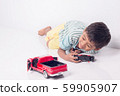 cute little boy play semi-automatic toy car on 59905907