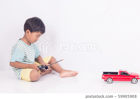 cute little boy play semi-automatic toy car on 59905908