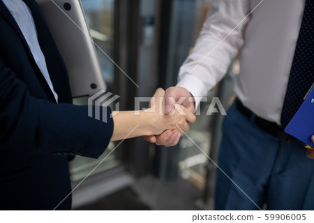 Close up of businesswoman shaking hand of her business partner 59906005