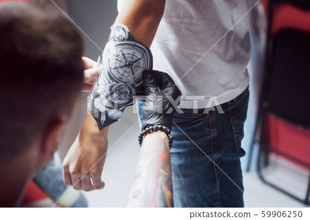 The tattoo artist sketches the drawing for his client 59906250