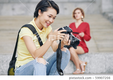 Happy photographer checking photos Happy photographer checking photos 59907208