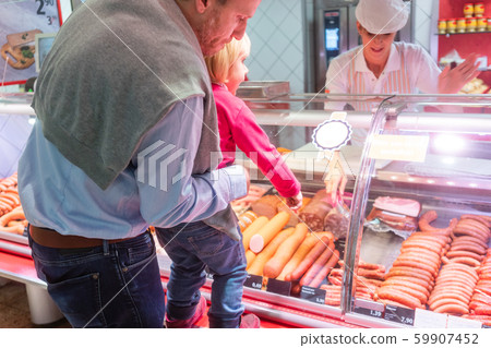 Family shopping for fresh meat in a supermarket 59907452