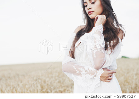 Beautiful girl in a field of wheat in a white dress, a perfect picture in the style lifestyle Beautiful girl in a field of wheat in a white dress, a perfect picture in the style lifestyle 59907527