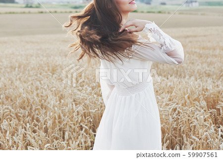 Beautiful girl in a field of wheat in a white dress, a perfect picture in the style lifestyle 59907561