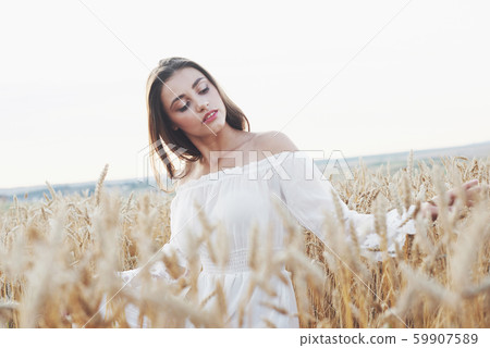 Beautiful girl in a field of wheat in a white dress, a perfect picture in the style lifestyle 59907589