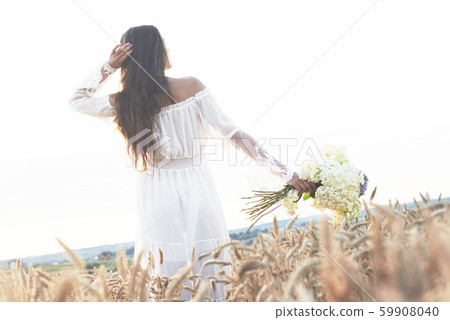 Young sensitive girl in white dress posing in a field of golden wheat Young sensitive girl in white dress posing in a field of golden wheat 59908040