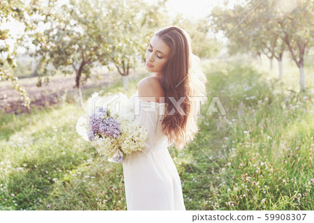 Beautiful young woman wearing elegant white dress and enjoying beautiful sunny afternoon in a summer Beautiful young woman wearing elegant white dress and enjoying beautiful sunny afternoon in a summer 59908307