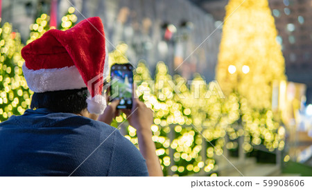 Man with Santa hat taking photo in Christmas event Man with Santa hat taking photo in Christmas event 59908606
