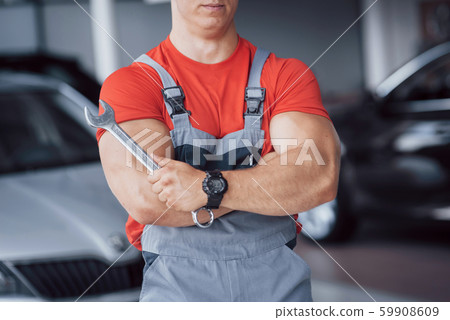 Hands of car mechanic with wrench in garage Hands of car mechanic with wrench in garage 59908609