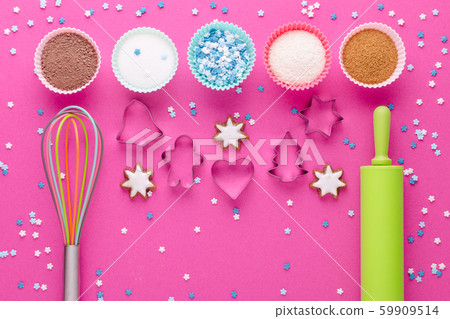 ingredients for baking and kitchen tools with cookie cutter on pink background, flat lay ingredients for baking and kitchen tools with cookie cutter on pink background, flat lay 59909514