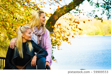 Two women walking in autumn park Two women walking in autumn park 59909553