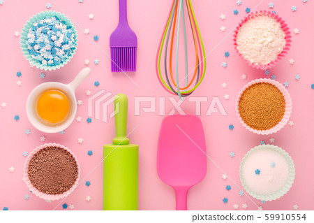 baking ingredients, egg, flour, cocoa, sugar, sweet decoration and kitchen tools on pink background 59910554