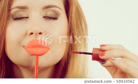 Woman applying lipstick or lip gloss Woman applying lipstick or lip gloss 59910562