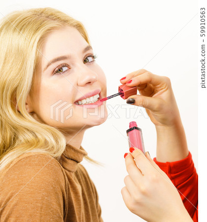 Woman applying lipstick or lip gloss 59910563