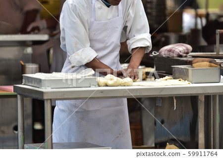 Indian restaurant stall, chef making dough for Nan 59911764
