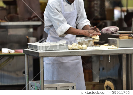Indian restaurant stall, chef making dough for Nan 59911765
