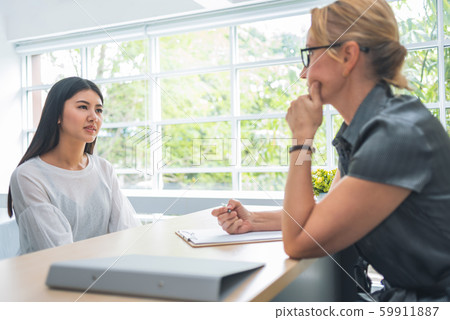 woman talking and listening to senior female 59911887