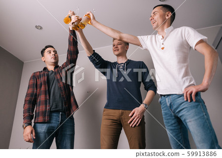 Happy friends clinking bottles of beer Happy friends clinking bottles of beer 59913886