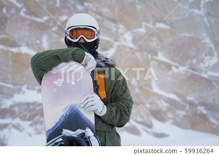 Photo of sports man in helmet, mask with snowboard on background of mountain . 59916264