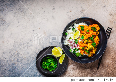 Vegetarian lentil curry with rice in black plate Vegetarian lentil curry with rice in black plate 59916916