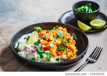Vegetarian lentil curry with rice in black plate. Vegetarian lentil curry with rice in black plate. 59916919