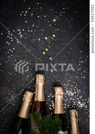 Bottles of champagne with gold glitter and space for text on dark background 59917082