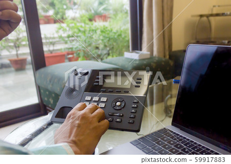 Business man dialing a phone number on a landline phone 59917883