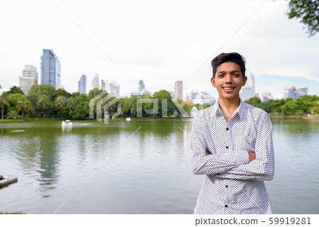 Portrait of young Indian teenage boy relaxing at the park Portrait of young Indian teenage boy relaxing at the park 59919281