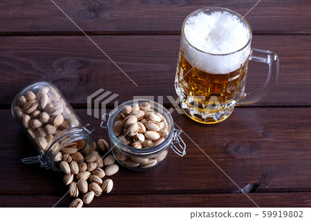 Pistachios in glass jars on a wooden background 59919802