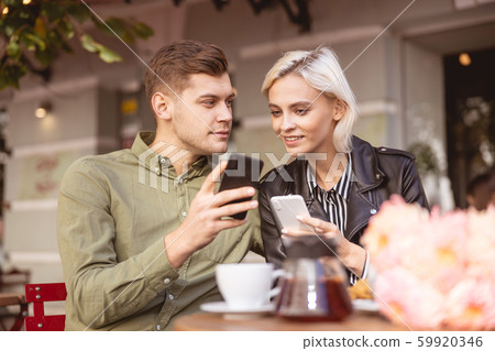 Couple discussing photos of their best friends 59920346