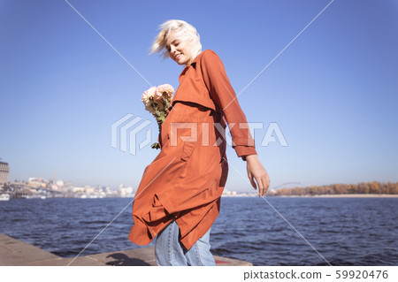 Pretty woman loving the wind near the river 59920476