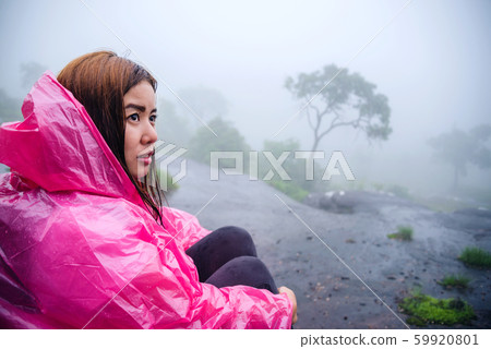 Girl with pink rain coat Sitting View the scenery natural beautiful  forest touch fog. travel nature 59920801